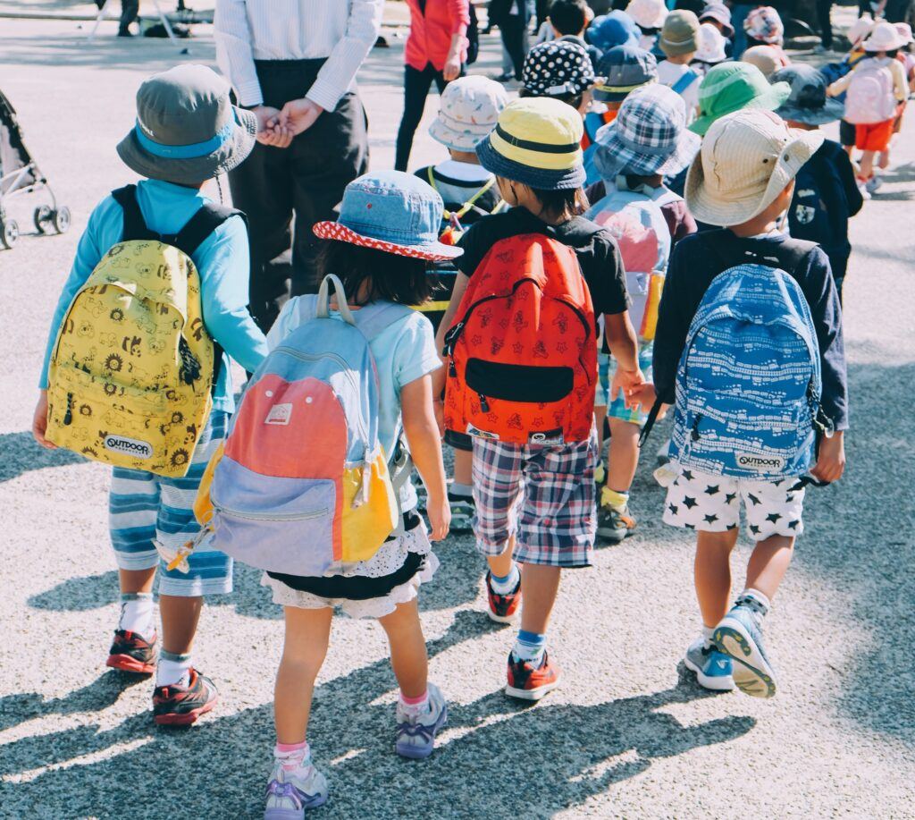 De jeunes élèves portant leur sac à dos sur le chemin de l'école